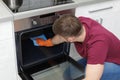 Young man cleaning oven with rag Royalty Free Stock Photo