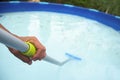 Young man cleaning a portable swimming pool Royalty Free Stock Photo