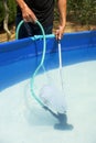 Young man cleaning a portable swimming pool