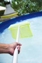 Young man cleaning a portable swimming pool Royalty Free Stock Photo