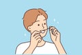 Young man cleaning teeth with dental floss