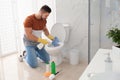 Young man cleaning toilet bowl Royalty Free Stock Photo