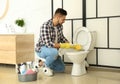 Young man cleaning toilet bowl Royalty Free Stock Photo