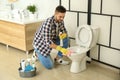 Young man cleaning toilet bowl Royalty Free Stock Photo