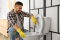Young man cleaning toilet bowl Royalty Free Stock Photo