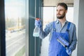 Young man cleaning window in office Royalty Free Stock Photo
