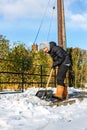 A young man clearing the footpath of snow and ice to make it safe to walk on during a heavy snowfall. Winter safety, clearing snow Royalty Free Stock Photo