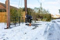 A young man clearing the footpath of snow and ice to make it safe to walk on during a heavy snowfall. Winter safety, clearing snow Royalty Free Stock Photo