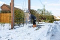 A young man clearing the footpath of snow and ice to make it safe to walk on during a heavy snowfall. Winter safety, clearing snow Royalty Free Stock Photo