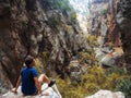 Young man climbed a rock, trekking in a gorge. Unity with nature.