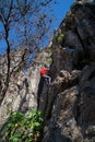 Young man climbing on a limestone wall with wide valley on the background Royalty Free Stock Photo