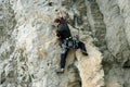 Young man climbing on a limestone wall with wide valley on the background Royalty Free Stock Photo