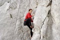 Young man climbing on a limestone wall with wide valley on the background Royalty Free Stock Photo