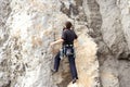 Young man climbing on a limestone wall with wide valley on the background Royalty Free Stock Photo