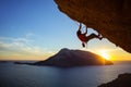 Young man climbing overhanging cliff at sunset Royalty Free Stock Photo