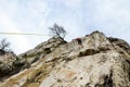 Young man climbing on rock. Climber climbs vertical and overhanging rock wall on mountain. Talented athlete with ropes climbs on r Royalty Free Stock Photo