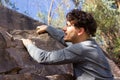 Young man climbing rock mountain on sunny day Royalty Free Stock Photo