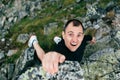 Young man climbing a steep wall in mountain. Rock-climb extreme sport. Tourist man hiking and climbing at mountains. Summer travel Royalty Free Stock Photo