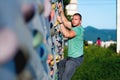 Young man climbing wall rock outdoors Royalty Free Stock Photo