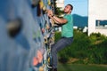 Young man climbing wall rock outdoors Royalty Free Stock Photo