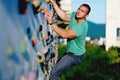 young man climbing wall rock outdoors Royalty Free Stock Photo