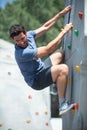 young man climbing wall rock outdoors Royalty Free Stock Photo