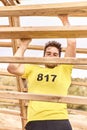 Young man climbing a wooden ladder in a Spartan race Royalty Free Stock Photo