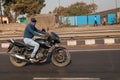 A young man with closet face in the sunglasses and without helmet rides a motorcycle.