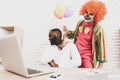 Young Man in Clown Costume with Baloons in Office. Royalty Free Stock Photo