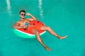 Young man with cocktail and inflatable ring in pool Royalty Free Stock Photo