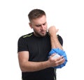 Young man with cold compress suffering from pain on white background