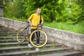 A young Man comes down the stairs with his Bicycle in a public Park Royalty Free Stock Photo