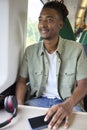 Young Man Commuting To Work Sitting On Train With Wireless Headphones And Mobile Phone Royalty Free Stock Photo