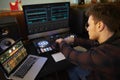 Young Man Composing Music on Laptop Computer in Bedroom Royalty Free Stock Photo