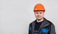 A young man construction worker in a safety helmet and work uniform on a white background, copy space for text Royalty Free Stock Photo
