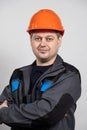 A young man construction worker in a safety helmet and work uniform on a white background Royalty Free Stock Photo