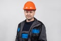 A young man construction worker in a safety helmet and work uniform on a white background Royalty Free Stock Photo