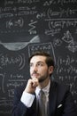 Young man contemplaiting in front of blackboard Royalty Free Stock Photo