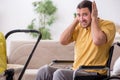 Young man contractor in wheel-chair looking after newborn Royalty Free Stock Photo