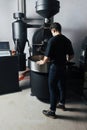 Young man controlling the roasting coffee process Royalty Free Stock Photo