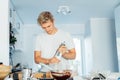 Young man cooking brownie cake on the light modern kitchen at home. Preparing steps for baking cake. Culinary hobby. Cooking Royalty Free Stock Photo