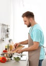 Young man cooking delicious vegetable soup Royalty Free Stock Photo