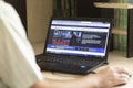 A young man during the coronavirus epidemic watches the World Banks website on a laptop at night