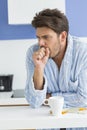 Young man coughing with coffee mug and medicine on kitchen counter