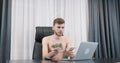 Young man counting dollar bills pile in the office. Male counts money sitting at her office desk. Man holding american one hundred