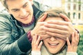 Young man covering the eyes of an happy surprised girlfriend