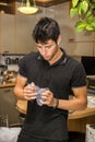 Young Man Crushing Plastic Water Bottle in Kitchen Royalty Free Stock Photo