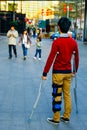 A young man on crutches looks at a happy family Royalty Free Stock Photo