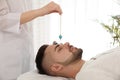 Young man during crystal healing session in room Royalty Free Stock Photo