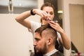 Young man cuts hair in the barber shop